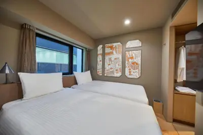 a bedroom with two white beds and a window at lyf Ginza Tokyo in Tokyo