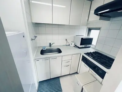 a small white kitchen with a sink and a microwave at Shinjuku-K-SJ0060 in Tokyo