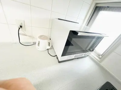 a microwave sitting on a counter in a kitchen at Shinjuku-K-SJ0060 in Tokyo