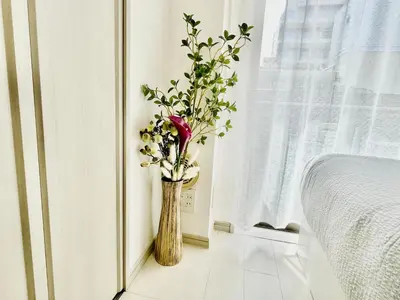 a vase of flowers sitting on the floor next to a window at Shinjuku-K-SJ0060 in Tokyo