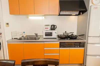 a kitchen with orange cabinets and a microwave at Asakusa-SK-TT0322 in Tokyo