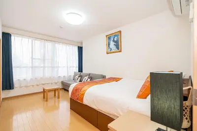 a bedroom with a bed and a couch and a window at Asakusa-SK-TT0322 in Tokyo
