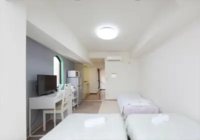 a room with two beds and a desk and a tv at Hirojo Building 203,303,403,603,703 - Vacation STAY 15419 in Tokyo