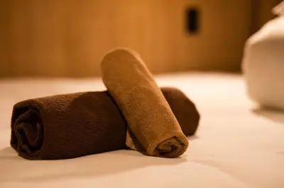 a towel animal is laying on a bed at THE BONDS HOTEL TOKYO in Tokyo