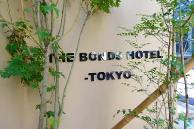 a sign on the side of a building with some trees at THE BONDS HOTEL TOKYO in Tokyo