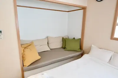a mirror reflection of a couch in a bedroom at Tatekawa 333 Residence - \u7acb\u5ddd\u4e09\u4e09\u4f4f\u5b85- crib free in Tokyo