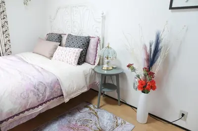 a bedroom with a bed and a table with a vase of flowers at Housegreen201 in Tokyo
