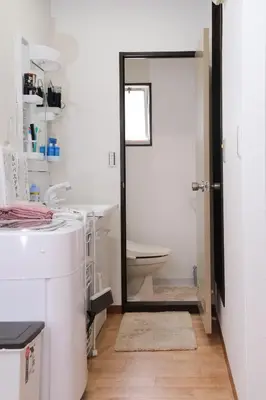 a bathroom with a toilet and a mirror at Housegreen201 in Tokyo