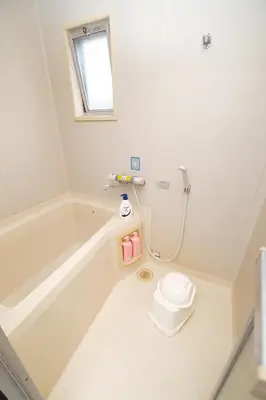 a white bathroom with a tub and a toilet at Housegreen201 in Tokyo