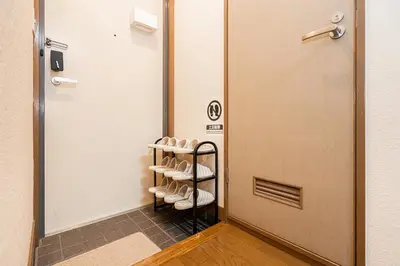 a room with a rack of shoes next to a door at \u62bc\u4e0a\u99c5\u304b\u3089\u5f92\u6b655\u5206 \u7121\u6599WiFi \u30b9\u30ab\u30a4\u30c4\u30ea\u304c\u773a\u671b\u3067\u304d\u307e\u3059 \u6700\u59276\u4ebaOK in Tokyo