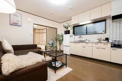 a living room with a couch and a kitchen at \u62bc\u4e0a\u99c5\u304b\u3089\u5f92\u6b655\u5206 \u7121\u6599WiFi \u30b9\u30ab\u30a4\u30c4\u30ea\u304c\u773a\u671b\u3067\u304d\u307e\u3059 \u6700\u59276\u4ebaOK in Tokyo