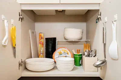 a shelf with plates and utensils in a kitchen at \u62bc\u4e0a\u99c5\u304b\u3089\u5f92\u6b655\u5206 \u7121\u6599WiFi \u30b9\u30ab\u30a4\u30c4\u30ea\u304c\u773a\u671b\u3067\u304d\u307e\u3059 \u6700\u59276\u4ebaOK in Tokyo