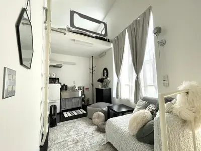 a living room with a bed and a living room with a couch at 1 stop to Shinjuku! Central NAKANO! up to 3ppl.cozy bright room. in Tokyo