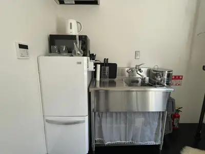 a kitchen with a white refrigerator and a sink at 1 stop to Shinjuku! Central NAKANO! up to 3ppl.cozy bright room. in Tokyo