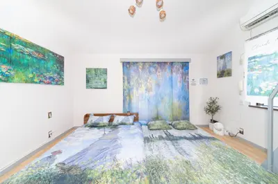 a bed in a room with paintings on the wall at Claude Monet Tokyo Shibuya Shinjyuku Wifi Free! in Tokyo