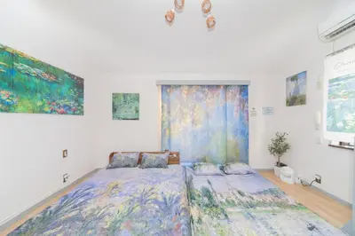 a bedroom with a bed and a painting on the wall at Claude Monet Tokyo Shibuya Shinjyuku Wifi Free! in Tokyo