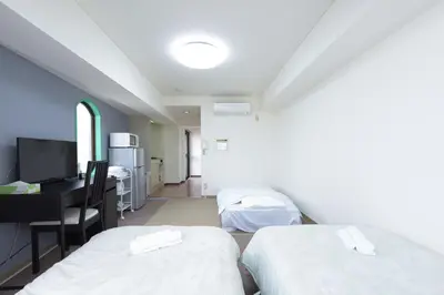 a room with two beds and a desk with a computer at Hirojo Building 203,303,403,603,703 - Vacation STAY 15452 in Tokyo