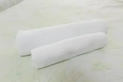 two rolls of white towels sitting on a bed at Hirojo Building 203,303,403,603,703 - Vacation STAY 15451 in Tokyo
