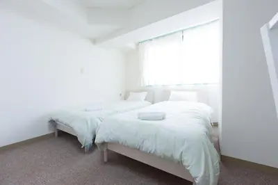 two beds in a white room with a window at Hirojo Building 203,303,403,603,703 - Vacation STAY 15451 in Tokyo