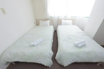 two beds in a room with white sheets and pillows at Hirojo Building 203,303,403,603,703 - Vacation STAY 15451 in Tokyo