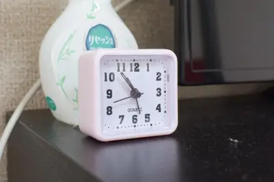 a clock sitting on a table next to a vase at Hirojo Building 203,303,403,603,703 - Vacation STAY 15454 in Tokyo