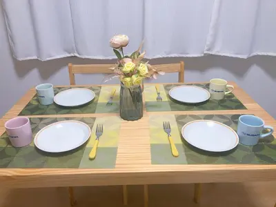 a table with plates and utensils and a vase of flowers at Stay Dream Hotel - Vacation STAY 75122v in Tokyo