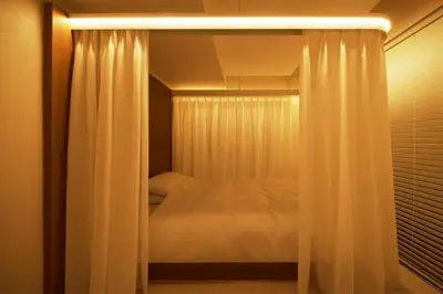 a bedroom with a bed with a curtain at SLEEPLAB THE STAY \u6e0b\u8c37 -\u7761\u7720\u7279\u5316\u578bHotel- in Tokyo
