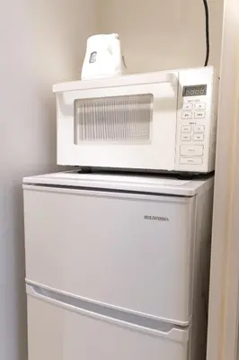 a microwave sitting on top of a refrigerator at SLEEPLAB THE STAY \u6e0b\u8c37 -\u7761\u7720\u7279\u5316\u578bHotel- in Tokyo
