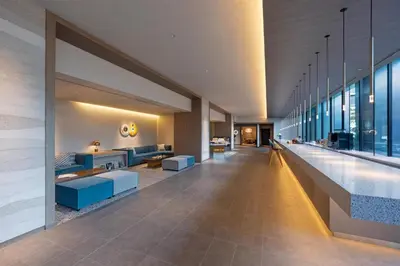 a lobby of a building with blue furniture and windows at Hyatt House Tokyo Shibuya in Tokyo