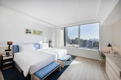 a hotel room with two beds and a large window at Hyatt House Tokyo Shibuya in Tokyo