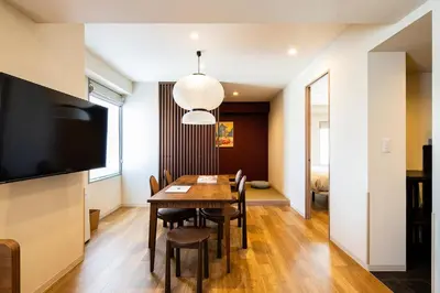 a dining room with a table and chairs and a flat screen tv at Section L Ueno-Hirokoji in Tokyo