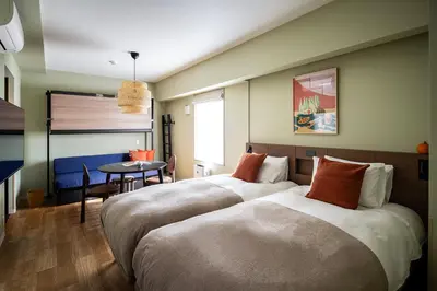 a bedroom with two beds and a table in it at Section L Ueno-Hirokoji in Tokyo
