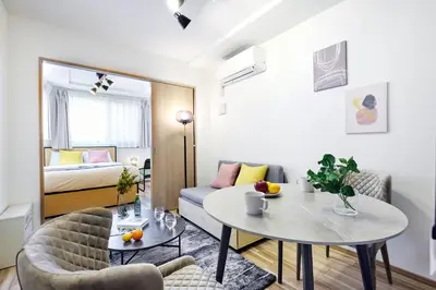 a living room with a table and chairs and a bed at \u30a6\u30a7\u30eb\u30b9\u30af\u30a8\u30a2\u30a4\u30ba\u30e0\u5927\u585a in Tokyo