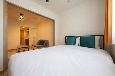 a bedroom with a large white bed and a chair at \u30a6\u30a7\u30eb\u30b9\u30af\u30a8\u30a2\u30a4\u30ba\u30e0\u5927\u585a in Tokyo