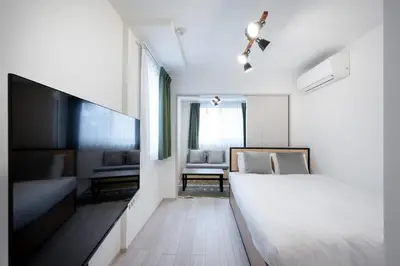 a bedroom with a bed and a tv and a couch at \u30a6\u30a7\u30eb\u30b9\u30af\u30a8\u30a2\u30a4\u30ba\u30e0\u5927\u585a in Tokyo