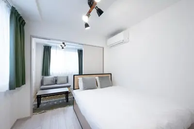 a white bedroom with a bed and a chair at \u30a6\u30a7\u30eb\u30b9\u30af\u30a8\u30a2\u30a4\u30ba\u30e0\u5927\u585a in Tokyo