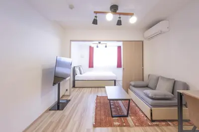 a living room with a couch and a television at \u30a6\u30a7\u30eb\u30b9\u30af\u30a8\u30a2\u30a4\u30ba\u30e0\u5927\u585a in Tokyo