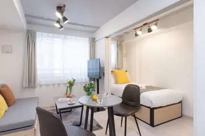 a small room with a bed and a table at \u30a6\u30a7\u30eb\u30b9\u30af\u30a8\u30a2\u30a4\u30ba\u30e0\u6c60\u888b\u30a4\u30fc\u30b9\u30c8 in Tokyo
