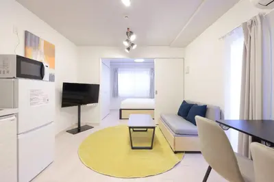 a living room with a couch and a table at \u30a6\u30a7\u30eb\u30b9\u30af\u30a8\u30a2\u30a4\u30ba\u30e0\u6c60\u888b\u30a4\u30fc\u30b9\u30c8 in Tokyo