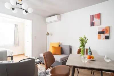 a living room with a couch and a table at \u30a6\u30a7\u30eb\u30b9\u30af\u30a8\u30a2\u30a4\u30ba\u30e0\u6c60\u888b\u30a4\u30fc\u30b9\u30c8 in Tokyo
