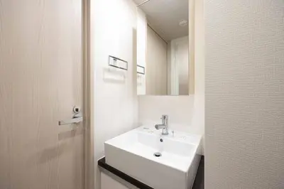 a white bathroom with a sink and a mirror at \u30a6\u30a7\u30eb\u30b9\u30af\u30a8\u30a2\u30a4\u30ba\u30e0\u6c60\u888b\u30a4\u30fc\u30b9\u30c8 in Tokyo