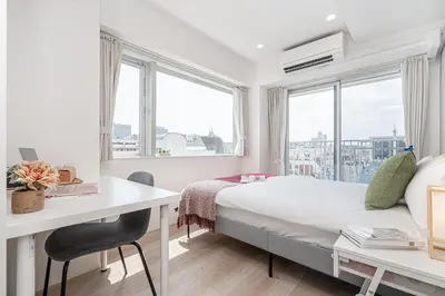 a bedroom with a bed and a desk and windows at ZAITO Tokyo Skytree Yokokawa III \u9326\u7cf8\u753a\u99c5\u304b\u3089\u5f92\u6b69\uff19\u5206 in Tokyo