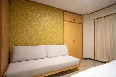 a couch in a room with a yellow wall at \u6bbf\u5802 in Tokyo