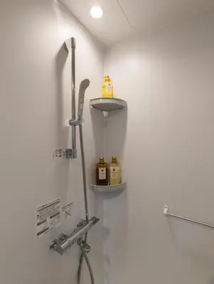 a bathroom with a shower with two bottles on a shelf at \u6bbf\u5802 in Tokyo