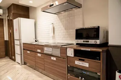 a kitchen with a microwave and a refrigerator at HOTEL PASELA LIVING - Vacation STAY 84860v in Tokyo