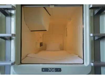 a small room with a bed inside of a clock at Male Only Capsule Inn Hamamatsucho - Vacation STAY 68799v in Tokyo