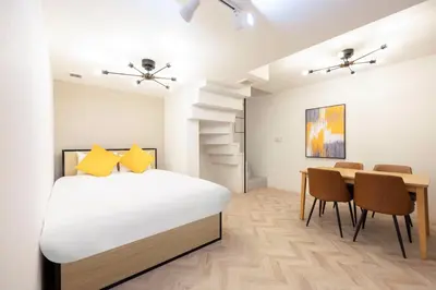 a bedroom with a bed and a table and chairs at HJ PLACE SHIBUYA in Tokyo