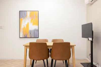 a dining room table with chairs and a painting at HJ PLACE SHIBUYA in Tokyo