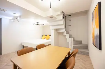 a room with a table and chairs and a bed at HJ PLACE SHIBUYA in Tokyo