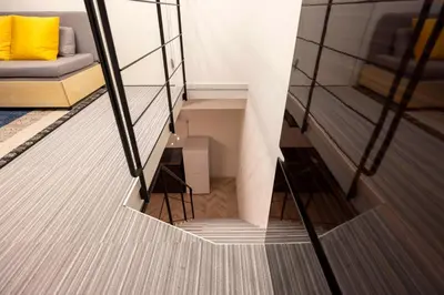 a spiral staircase in a room with a yellow pillow at HJ PLACE SHIBUYA in Tokyo